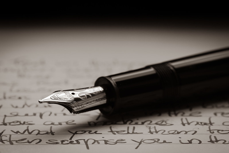 Header image: black fountain pen with silver nib resting on a handwritten page
