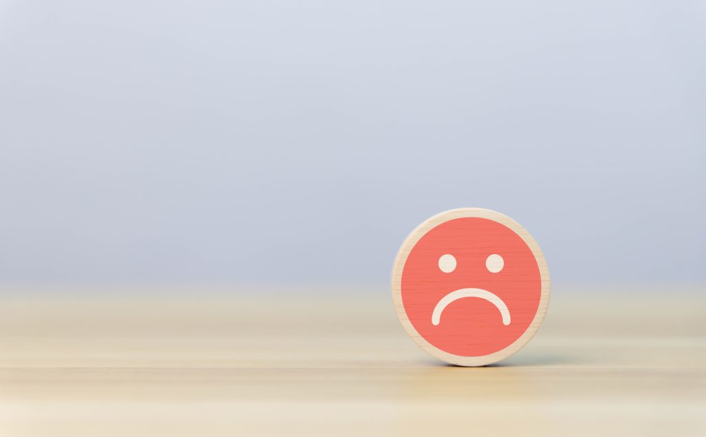 Header image: round wooden block with a red angry face graphic, standing on end on a blond wood table against a pale blue background (Credit: VRVIRUS / Shutterstock.com)